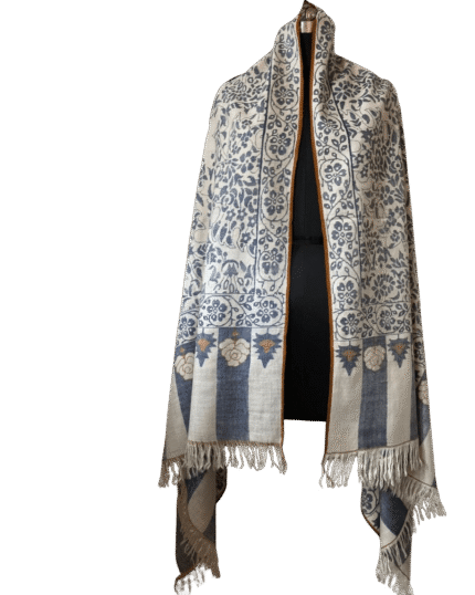 Handmade Qalamkar shawl in beige wool with traditional geometric border and fringed edges, displayed on a mannequin.