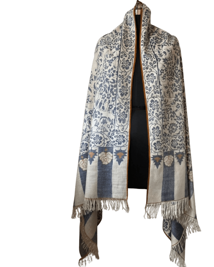 Handmade Qalamkar shawl in beige wool with traditional geometric border and fringed edges, displayed on a mannequin.