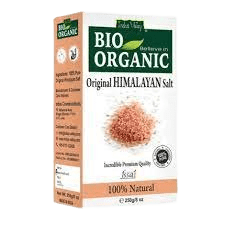 A resealable pouch of pink Himalayan salt with a kraft paper label reading "Himalayan Salt – 100% Natural", placed beside a wooden bowl filled with salt crystals on a rustic wooden surface.